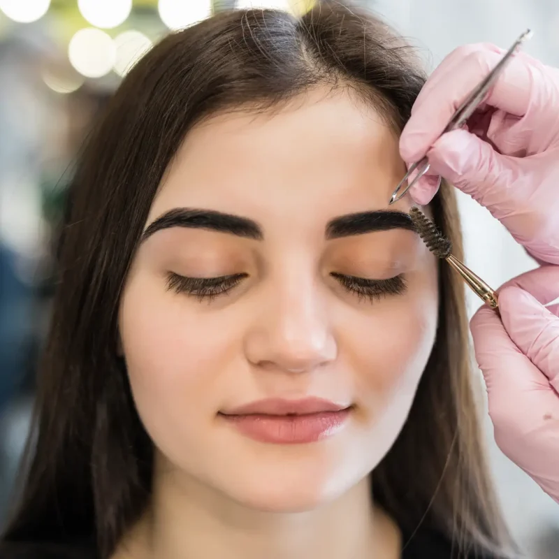 master-doing-final-steps-make-up-procedure-model-with-green-eyes